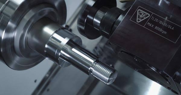 Pieza de precisión siendo maquinada en torno CNC